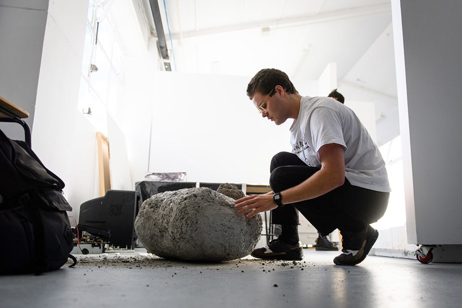 At work in the Fine Arts studio Student in fine arts studio with concrete rock work on floor.